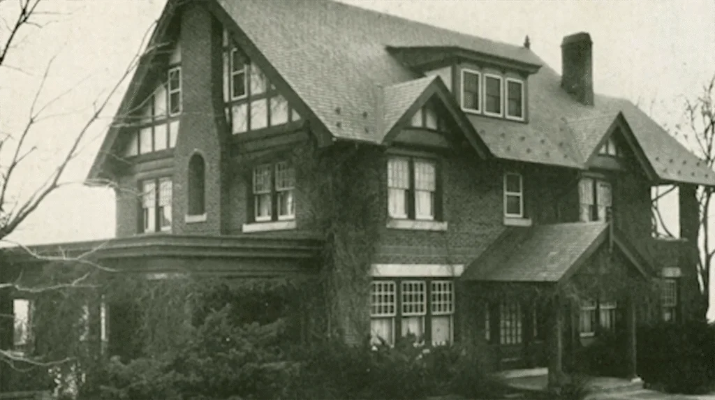 A black and white image of a large brick home